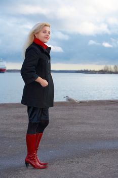Young woman standing in harbor, looking at camera