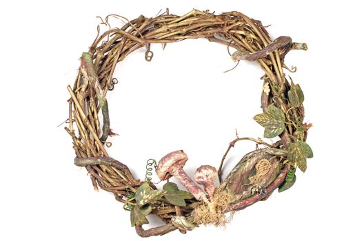 Wreath made with straw and mushrooms on white background.