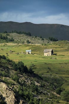 Little houses and sunlight in the mountain by cloudy summer