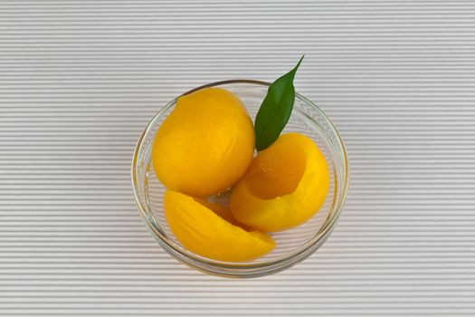 Canned Peaches in sweet syrup on  glass jar.