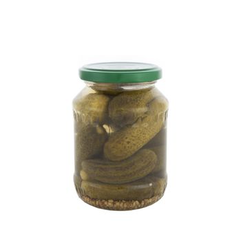 Jar of cocktail pickles with green lid on white background.