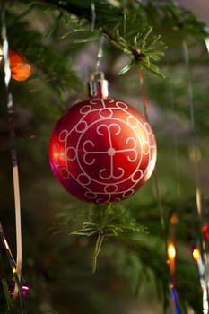 Red Christmas ornament hanging on Christmas tree.