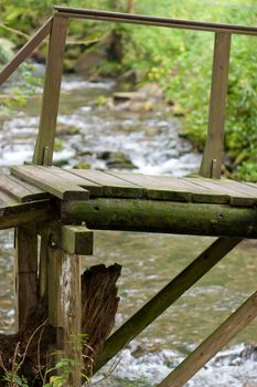 Close-up view of a wooden pontoon over a small mountain river