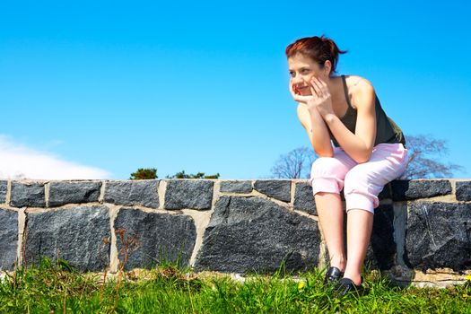 Teenage girl sitting wearing sportswear outdoors