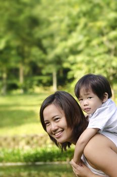 Asian mother and son having fun in park