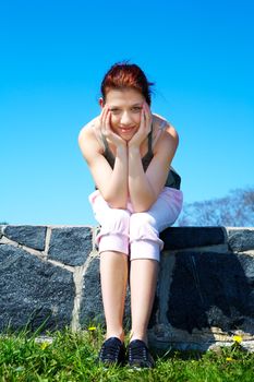 Teenage girl sitting wearing sportswear looking at camera