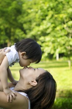 Outdoor park mother kissing son