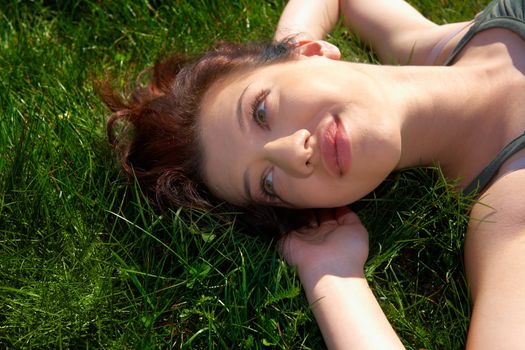 Teenage girl laying in grass smiling