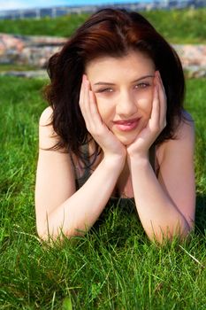 Teenage girl laying in grass looking at camera