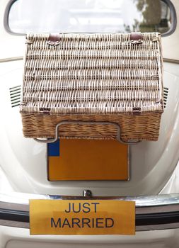 White just married car in Netherlands with suitcase on the back