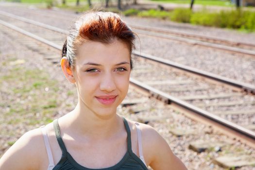 Teenage girl standing by railroad tracks