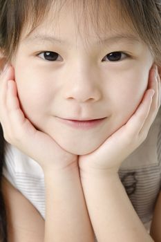 Close-up shot of a young Asian girl with smile on her face.