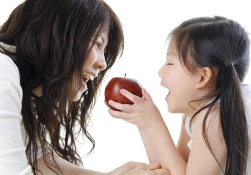 Mother and daughter sharing an apple on white background
