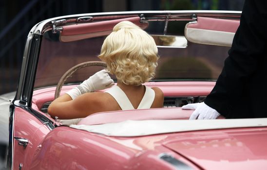 Blond girl model like Marilyn Monroe in car
