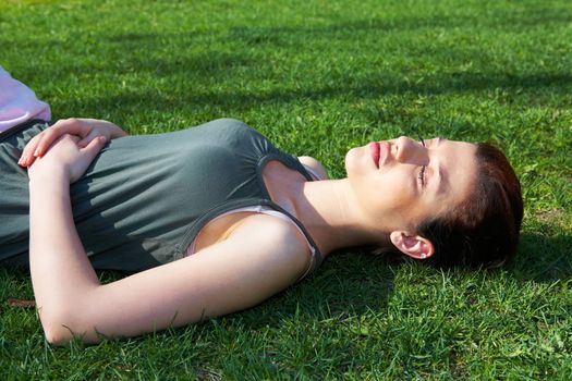 Teenage girl resting in park eyes closed