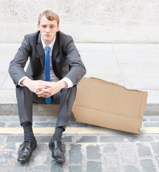 A worried business man sitting on some stairs