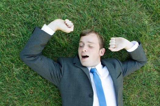 A business man lying on the grass