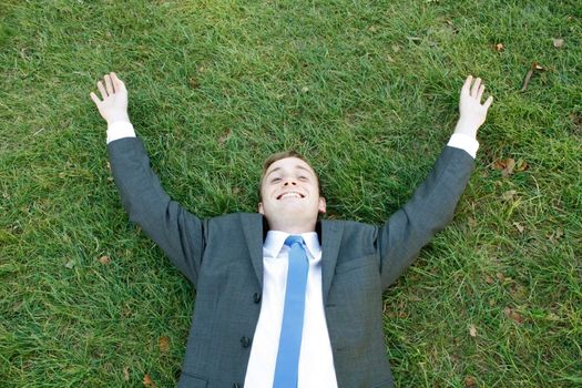 A business man lying on the grass