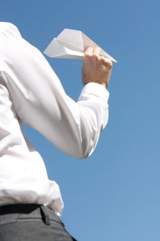 A business man throwing a paper plane