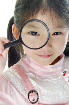A little girl peers at the camera through a magnifying glass.