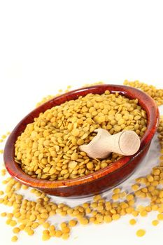 a red bowl with yellow lentils and shovel