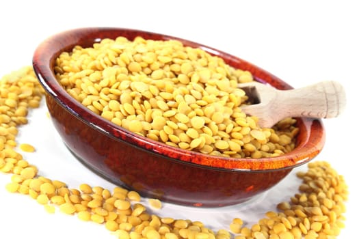 a red bowl with yellow lentils and shovel