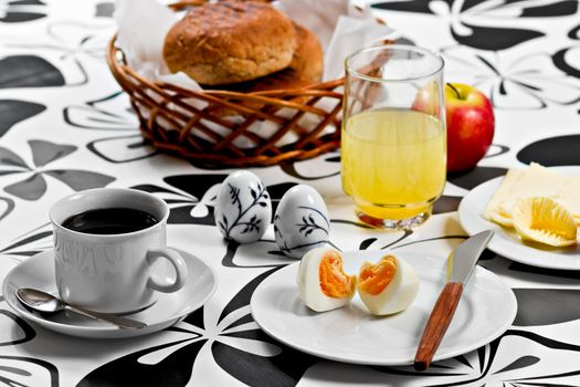 Breakfast with heart shaped egg, coffee, orange juice, bread, butter, cheese and an apple