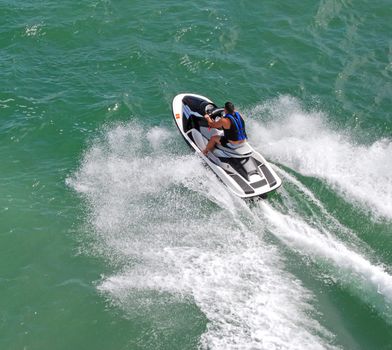 angled overhead view of a man going across biscayne bay near miami beach,florida on a jetski.