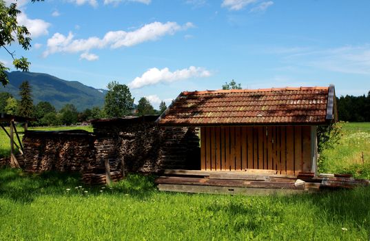 alpine landscape with house with firewoods