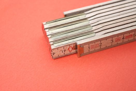 Wooden ruler isolated on red