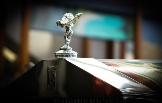 an silver sparkling rolls royce angel emblem on the retro hood