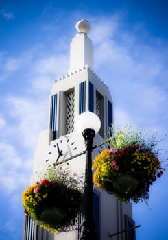 time tower and flowerpots in azure sky with white clouds