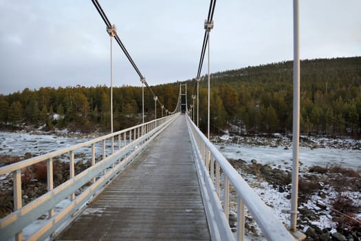 Pedestrian bridge over the river. winter Landscape