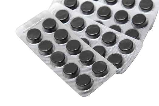 Black pills in packs over white background