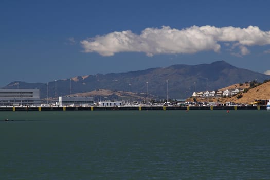 Wharf on sunny day with mountain on background