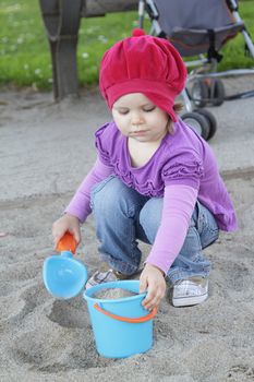 Little girl playing with sand on a playground