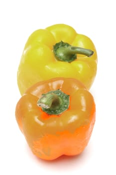 Two peppers, yellow and orange, isolated on white background