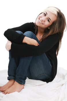 attractive teenage girl sits twining arms about legs