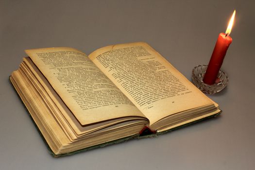 a book and a candle on the grey background