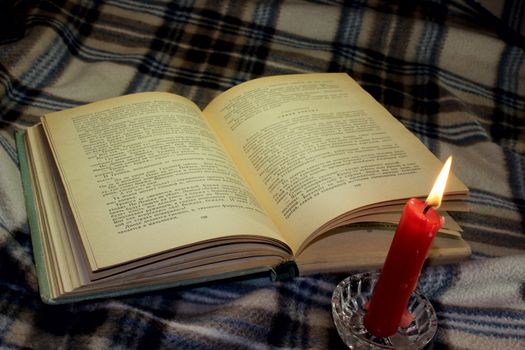 a book and a candle on the plaid