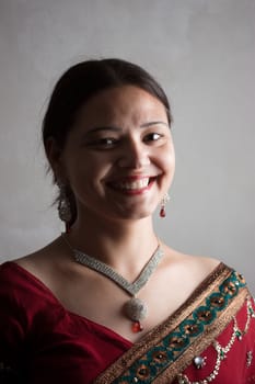 Smiling Indian happy woman wearing  beautifully embroidered red sari