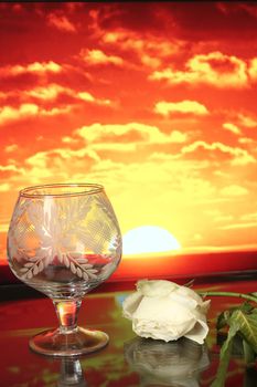 a goblet and the flower on the sunset background