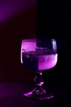 a glass of wine on the black and violet background.