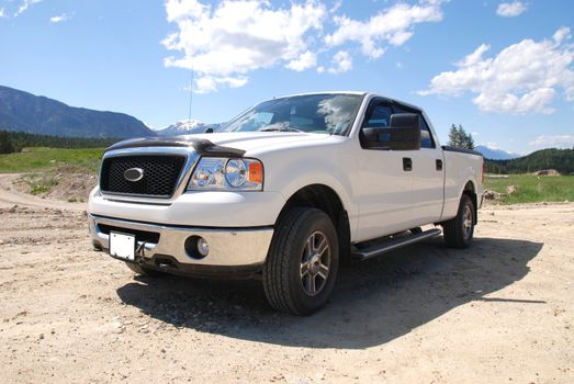 Pick-up truck on a dirt road in the mountains.