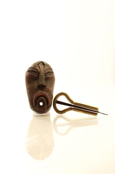 a Jew's-harp and a little shaman's mask on the white background