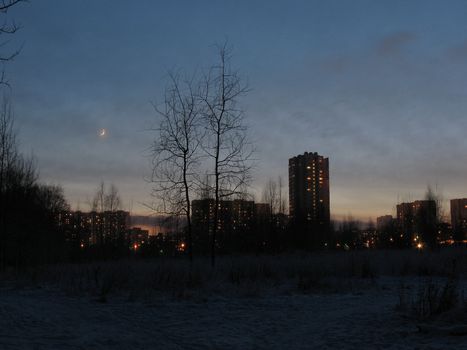 A silky moon, evening sky, lights of the big city and snow. It is romantic, isn't it? 