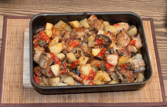 Meat ragout with vegetables on a baking sheet.