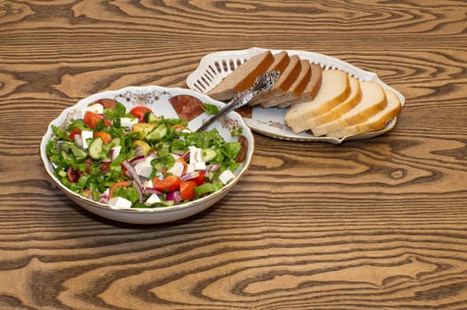 Greek salad and bread on the table.