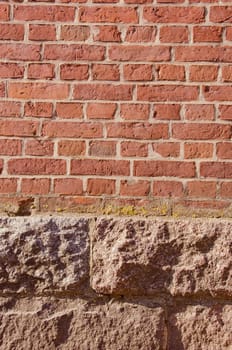 Wall made of red bricks and concrete blocks at the bottom. Background.