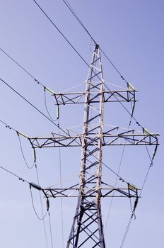 High-voltage electricity wires and poles in the background of sky.